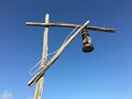 Old rusty kerosene lamp with a white wire on a street wooden post crane