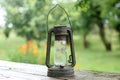 Old and rusty kerosene lantern hanging at cabin have bokeh as background
