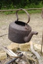 Old rusty kettle over open fire