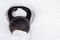 Old rusty kettlebell for winter training street workout in snow