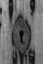 Old rusty key hole in an old wooden door in black and white Royalty Free Stock Photo