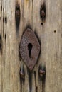 Old rusty key hole in an old wooden door Royalty Free Stock Photo