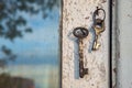 Old rusty key on the shabby wooden door frame with broken white paint Royalty Free Stock Photo