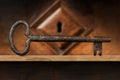 Old Rusty Key and a Wooden Keyhole on a Wood Shelf Royalty Free Stock Photo