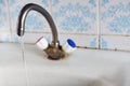 Old, rusty kitchen mixer mounted on an enameled sink