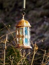 Old rusty lantern hanging above dried branch