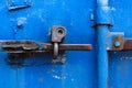 old rusty lock on the bright blue door of a metal sea container, close-up Royalty Free Stock Photo