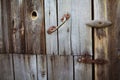 Old rusty lock hanging on the gray wooden door. Royalty Free Stock Photo