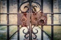 Old and rusty lock on ornate, locked iron gates of a church