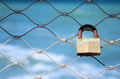 Old rusty lock over iron fence with blue sea background. Royalty Free Stock Photo