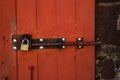 Old rusty lock on a red wooden door. Royalty Free Stock Photo