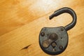 Old rusty lock on a wooden table. Vintage padlock on the wood background Royalty Free Stock Photo