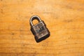 Old rusty lock on a wooden table. Vintage padlock on the wood background Royalty Free Stock Photo