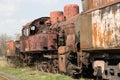 Old rusty locomotive stands on the rails on the background of blue sky