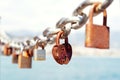 Old rusty love locks on chain against the sea. Close-up. Selective focus. Blurred background Royalty Free Stock Photo