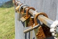 Old rusty love padlocks hanging on railing outdoors Royalty Free Stock Photo