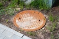 Old rusty manhole in the grass closeup Royalty Free Stock Photo