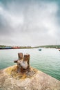 Old rusty metal bollard and ships in the Dingle harbour at hazy day