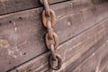 Old rusty metal chains on the wooden background in selective focus Royalty Free Stock Photo