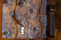 old rusty metal door lock. Dilapidated wooden door. The entrance to the ancient Catholic temple. Keyhole close-up Royalty Free Stock Photo