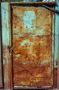 Old rusty metal door, painted green which becames orange from rust Royalty Free Stock Photo