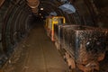 Old and rusty metal mine train with wagons in mine tunnel with wooden timbering Royalty Free Stock Photo