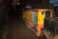 Old and rusty metal mine train with wagons in mine tunnel with wooden timbering Royalty Free Stock Photo