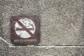 Old rusty metal no smoking allowed sign on dirty pebbles stone wall texture in public place Royalty Free Stock Photo