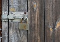 Old rusty metal padlock on shabby wooden door background. Royalty Free Stock Photo