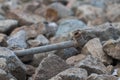 An old rusty metal pipe lies in the stones Royalty Free Stock Photo