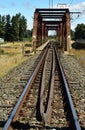 Old and rusty metal railway bridge and train tracks Royalty Free Stock Photo