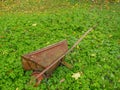 Old rusty metal wheel barrow on a field in a green grass Royalty Free Stock Photo