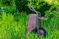Old rusty metal wheelbarrow abandoned in backyard of a farmhouse Royalty Free Stock Photo