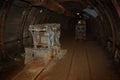 Old and rusty mine machine and train with wagons in mine shaft with wooden timbering Royalty Free Stock Photo