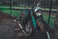 Stary Oskol, Russia January 25, 2019: Old rusty motorcycle near fence on ground. Close up of abandoned broken motorbike.