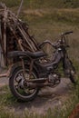 Old rusty motorcycle stands near heap of scrap metal