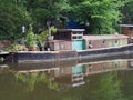 Old rusty narrow boat reflected in the water and surrounded by trees on the rochdale canal in hebden bridge west yorkshire Royalty Free Stock Photo