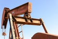 Old rusty oil derrick in sunlight with blue sky Royalty Free Stock Photo