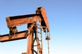 Old rusty oil derrick in sunlight with blue sky Royalty Free Stock Photo