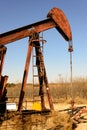 Old rusty oil derrick in sunlight with blue sky Royalty Free Stock Photo