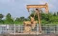 Old rusty oil pump jack extracting crude oil and natural gas from well in green background Royalty Free Stock Photo