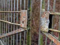 Old rusty open gate with broken lock, ajar