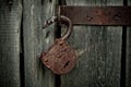 Old rusty opened lock without key. Vintage wooden door, close up concept photo