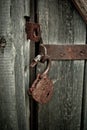 Old rusty opened lock without key. Vintage wooden door, close up concept photo