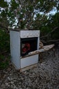 Old rusty oven outside with a red lantern inside
