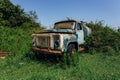 Old rusty overgrown truck. Abandoned Soviet tank car in ghost town Royalty Free Stock Photo