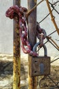 An old, rusty padlock with a chain hanging from the gate Royalty Free Stock Photo