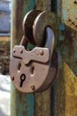 An old, rusty padlock with a chain hanging from the gate Royalty Free Stock Photo