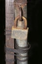 Rusted padlock on old metal pole with twisted rope Royalty Free Stock Photo