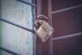 Old rusty padlock hanging on old rusty metal fence bars Royalty Free Stock Photo